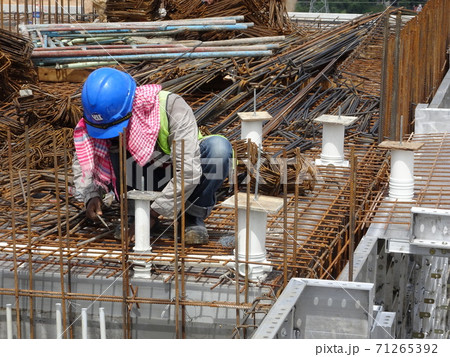 KUALA LUMPUR, MALAYSIA -MARCH 14, 2017: Construction workers install and fabricating floor slab reinforcement bar at the construction site. The reinforcement bar is tie together using tiny wire.  71265392