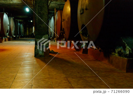 Large storage tanks where grape juice is aged into wine located in a wine cellar Large storage tanks where grape juice is aged into wine located in a wine cellar 71266090