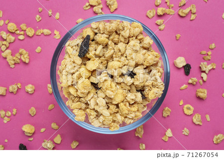 Cereal. Breakfast with muesli and raisins on a pink background. Space for text. Top view. 71267054