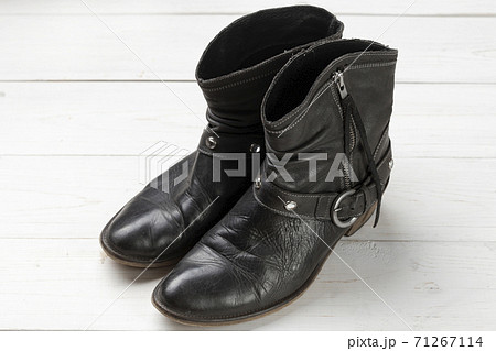 Women cowboy boot. Black leather shoes on a white wooden table. Composition of clothes. Flatlay. Women cowboy boot. Black leather shoes on a white wooden table. Composition of clothes. Flatlay. 71267114