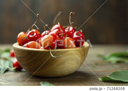 Fresh cherries with leaves in a wooden bowl Fresh cherries with leaves in a wooden bowl 71268208