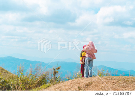 Back view of Muslim women wearing a Muslim dress and hijab enjoy on the highest point and the beautiful view landscape in morning at Elephant Hills View Point are located in Thong Pha Phum Back view of Muslim women wearing a Muslim dress and hijab enjoy on the highest point and the beautiful view landscape in morning at Elephant Hills View Point are located in Thong Pha Phum 71268707