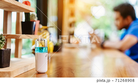 Alcohol nano mist sprayer for hand cleaning to prevent the spread of the Corona virus (Covid-19) to serve customers at coffee shop. Modern health technology. New normal lifestyle. Selective focus 71268908