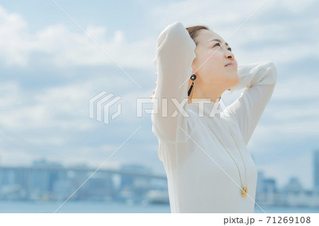 両手で髪を整える女性 71269108