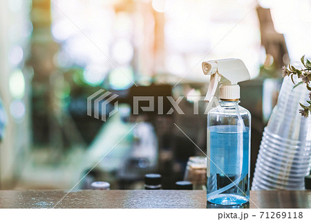 Blue alcohol sprayer bottle for hands cleaning to prevent the spreading of the Corona virus (Covid-19),Place the entrance service for customers  in the cafe. Healthcare concept. New normal lifestyle. 71269118
