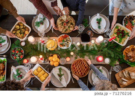 Top view of hands of family members holding plates with homemade food 71270216