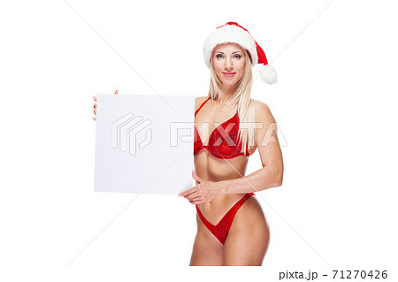 Sexy female bodybuilder in a red swimsuit and Christmas hat, copy space, isolated on white 71270426