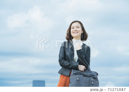 笑顔で通勤するカジュアルな服装のビジネスウーマン 71271087