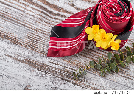 Rolled red tie with yellow flowers. Rolled red tie with yellow flowers. 71271235