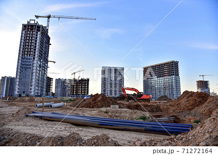 Large construction site with tower cranes and buildings on sunset background. Large construction site with tower cranes and buildings on sunset background. 71272164