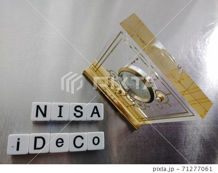 明るい光の中でIDECO NISAと並べられたサイコロ文字と時計 71277061