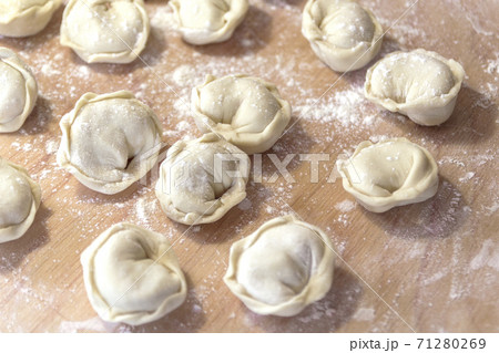 Closeup on semi-finished pelmeni dumplings on the wooden board. 71280269