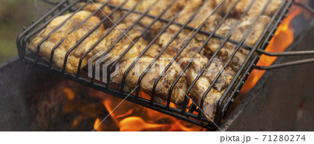 Grilled chicken on the grill. Processcooking chicken legs on a barbecue grill outdoorsflames and smoke on the background. 71280274