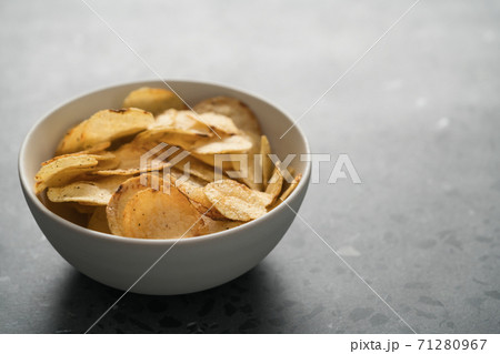 Organic potato chips with black pepper in white ceramic bowl on concrete background with copy space 71280967