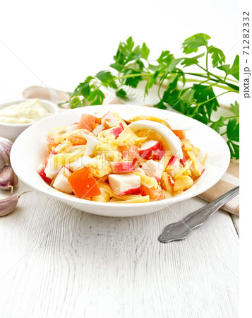Salad of surimi and tomatoes with eggs on board 71282332