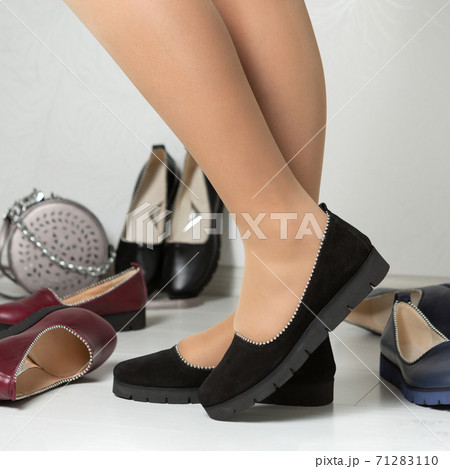female legs in black leather casual shoes with low soles, the concept of autumn shopping female legs in black leather casual shoes with low soles, the concept of autumn shopping 71283110