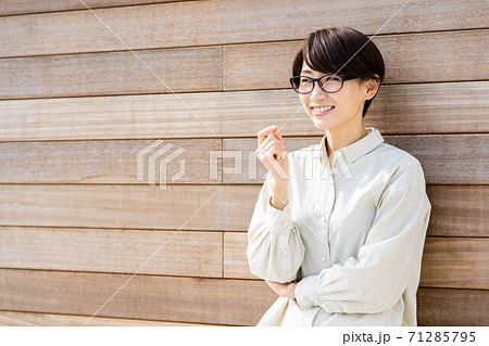 ウッドフェンスの前で微笑む女性 ウッドフェンスの前で微笑む女性 71285795