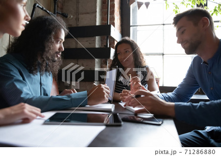 Diverse young multiethnic business partners having informal meeting at cafe Diverse young multiethnic business partners having informal meeting at cafe 71286880
