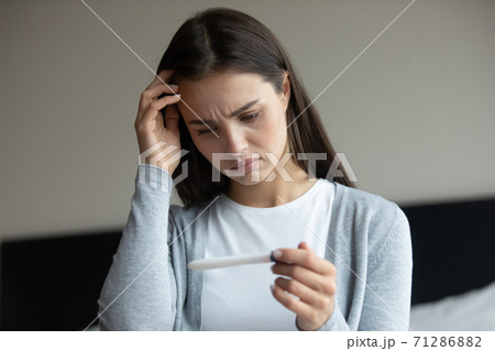Sad woman getting negative result of pregnancy test after ivf 71286882