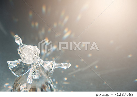 Crystal glass angel in the rays of the sun with reflecting, embossed sparkle. Faith, hope, mercy concept 71287668