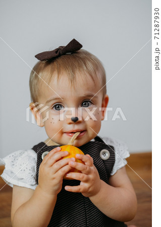 Halloween Thanksgiving Makeup Ideas for Kids and Baby. Happy funny baby with a pumpkin on home background 71287930
