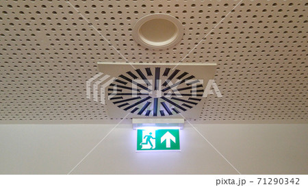 Small green emergency exit sign in office	 71290342