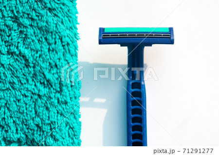 The razor lies near a green towel 71291277
