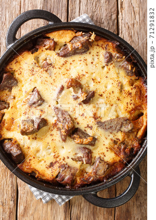Tave kosi soured milk casserole of lamb and rice baked with a mixture of yogurt and eggs closeup in the pan. vertical top view Tave kosi soured milk casserole of lamb and rice baked with a mixture of yogurt and eggs closeup in the pan. vertical top view 71291832