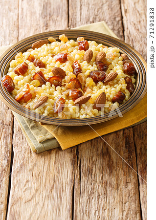 Mesfouf Algerian sweet couscous with nuts and raisins close-up in a plate. vertical Mesfouf Algerian sweet couscous with nuts and raisins close-up in a plate. vertical 71291838