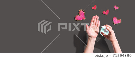 Applying sanitizer for cleaning hands with heart drawings Applying sanitizer for cleaning hands with heart drawings 71294390