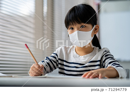 マスクをしながら勉強する小学生の写真素材 マスクをしながら勉強する小学生の写真素材