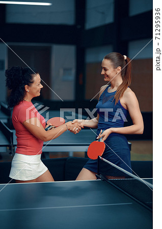 Women shake hands before table tennis match 71295936