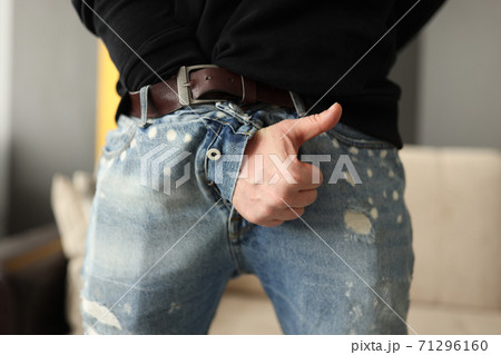Male hand sticking out of fly of his jeans and showing thumb up close-up 71296160