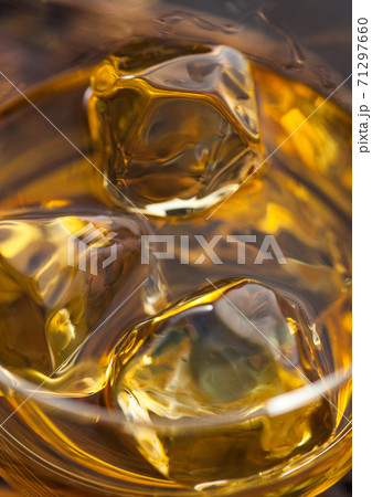 Ice cubes in scotch bourbon whiskey. Macro 71297660