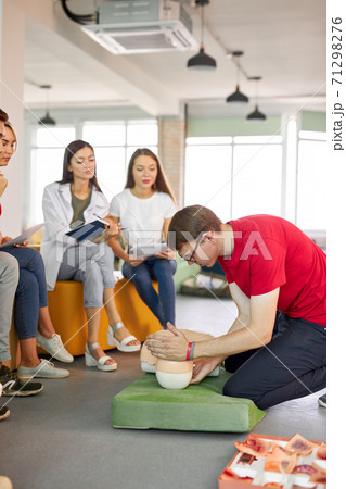 CPR class with caucasian instructors speaking and demonstrating help first aid 71298276