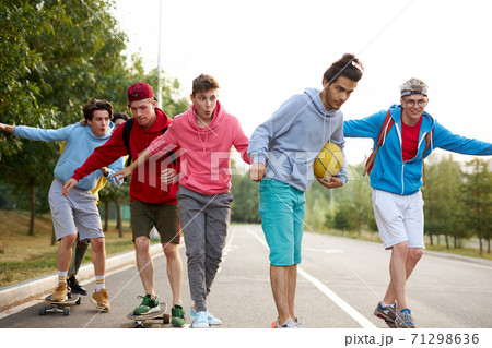 modern friendly guys in casual clothes skateboarding and showing exciting tricks modern friendly guys in casual clothes skateboarding and showing exciting tricks 71298636