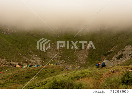 Morning rain and fog near a mountain lake, Carpathian lake Brebeneskul, a tent camp in the fog. Morning rain and fog near a mountain lake, Carpathian lake Brebeneskul, a tent camp in the fog. 71298909
