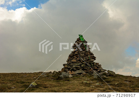 Tourists in raincoats stand on top of the mountain, Mount Brebeneskul and fog, rain clouds on the Montenegrin ridge, happy tourists. 71298917