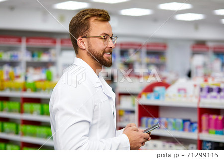 side view on pharmacist man using smartphone at work side view on pharmacist man using smartphone at work 71299115