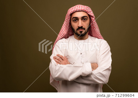 Muslim man. Portrait of a young arab man in traditional dress.  71299604