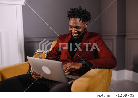 a black man works at a laptop close-up of his face. video conferences 71299705