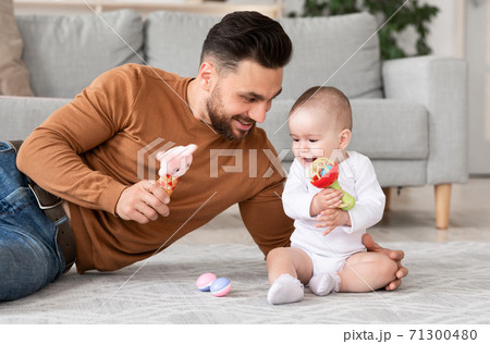 Happy Father Playing With Baby Holding Toys In Living Room 71300480