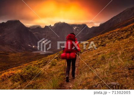 Woman Backpacking on Scenic Hiking Trail to Lake surrounded by Mountains Woman Backpacking on Scenic Hiking Trail to Lake surrounded by Mountains 71302005