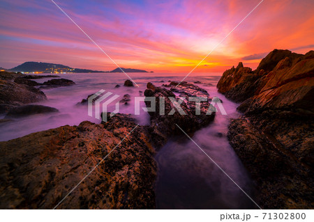 Long exposure image of Dramatic sky seascape with rocks in the foreground sunset or sunrise over sea scenery background. Long exposure image of Dramatic sky seascape with rocks in the foreground sunset or sunrise over sea scenery background. 71302800