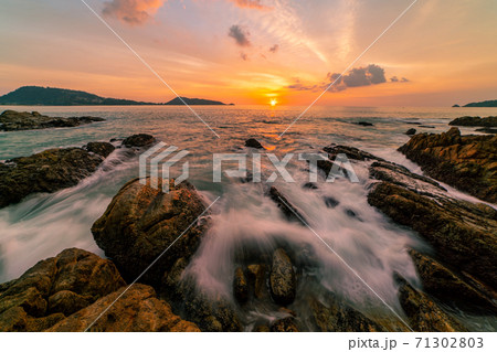 Long exposure image of Dramatic sky seascape with rocks in the foreground sunset or sunrise over sea scenery background. Long exposure image of Dramatic sky seascape with rocks in the foreground sunset or sunrise over sea scenery background. 71302803