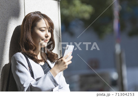 スマホで連絡をとるビジネスウーマン 71304253