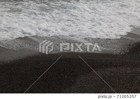 黒い砂浜に打ち寄せる小さな波 71305207
