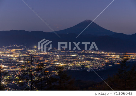 紅葉の甘利山から夕方の富士山と甲府盆地夜景の写真素材