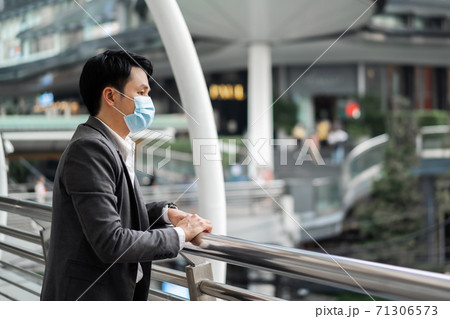 business man thinking and wearing medical mask during coronavirus (covid-19) pandemic in city business man thinking and wearing medical mask during coronavirus (covid-19) pandemic in city 71306573