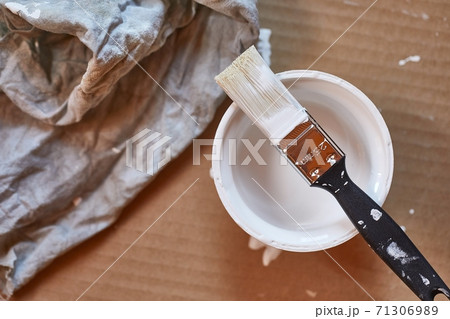 Paint brush on a can of white wall paint 71306989